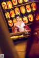 A woman in a red and white dress sitting in front of a mirror.