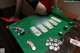 A woman in stockings and high heels playing poker on a table.