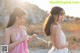 A couple of women standing next to each other on a beach.