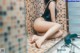 A woman sitting on the edge of a bathroom sink.