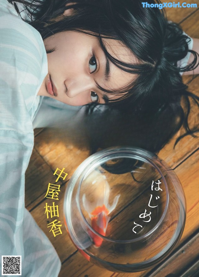 A woman laying on the floor next to a bowl of fish.