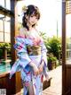 A woman in a kimono standing on a wooden deck.