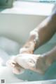 A person washing their feet in a bathtub with foam.