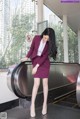 A woman in a business suit standing on an escalator.