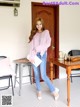 A woman standing in front of a wooden table.