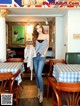 A woman standing in front of a table in a restaurant.