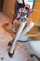 A woman in fishnet stockings and high heels is holding a whip.