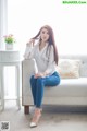 A woman sitting on a white couch in a room.