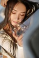 A woman holding a glass of water in her hand.