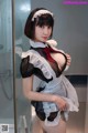 A woman in a maid outfit posing for the camera.