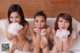 A group of three young women in a bathtub with foam.