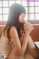 A woman sitting on a table drinking from a glass.